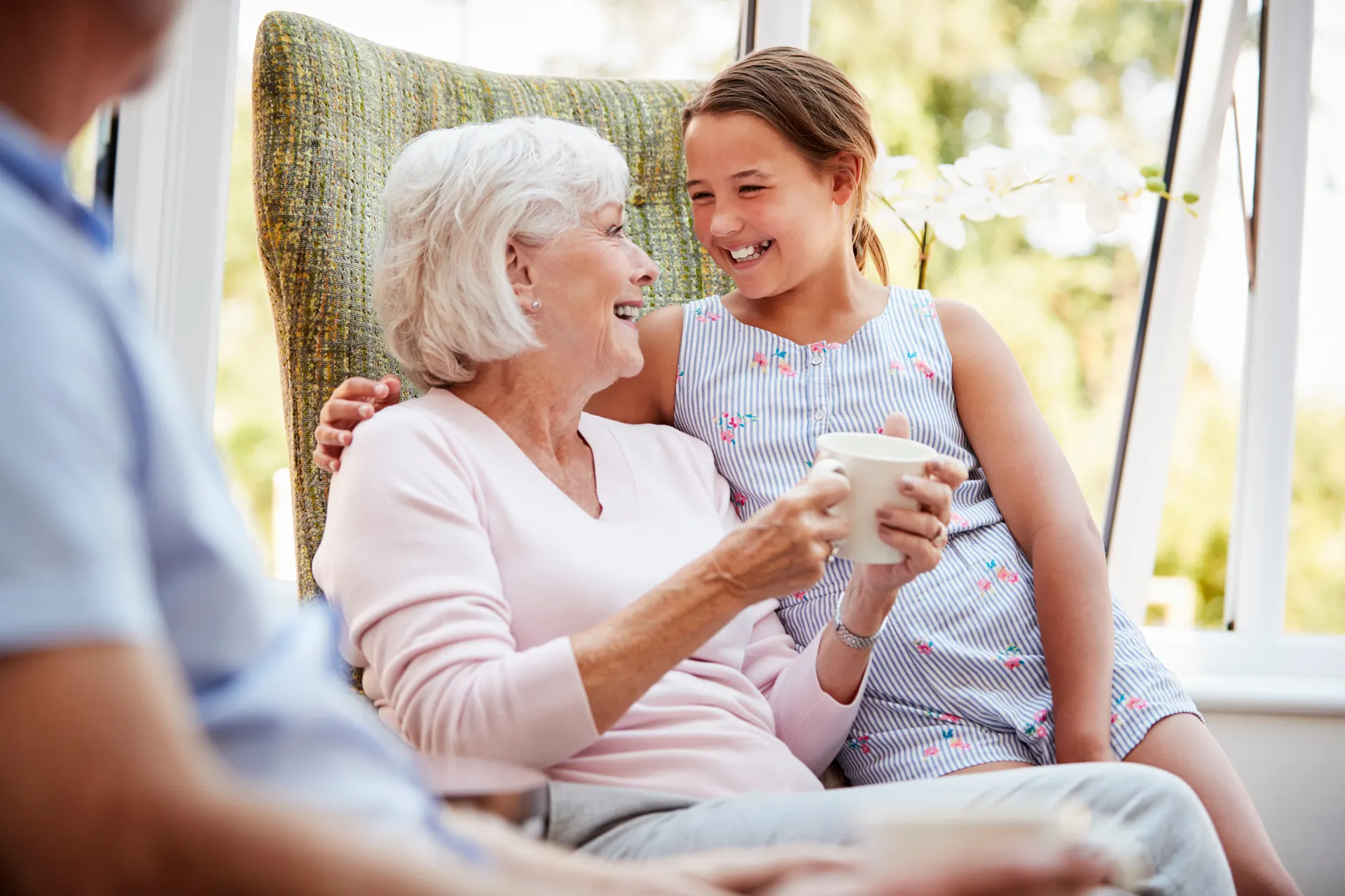 A granddaughter visiting her grandmother in a retirement community lounge